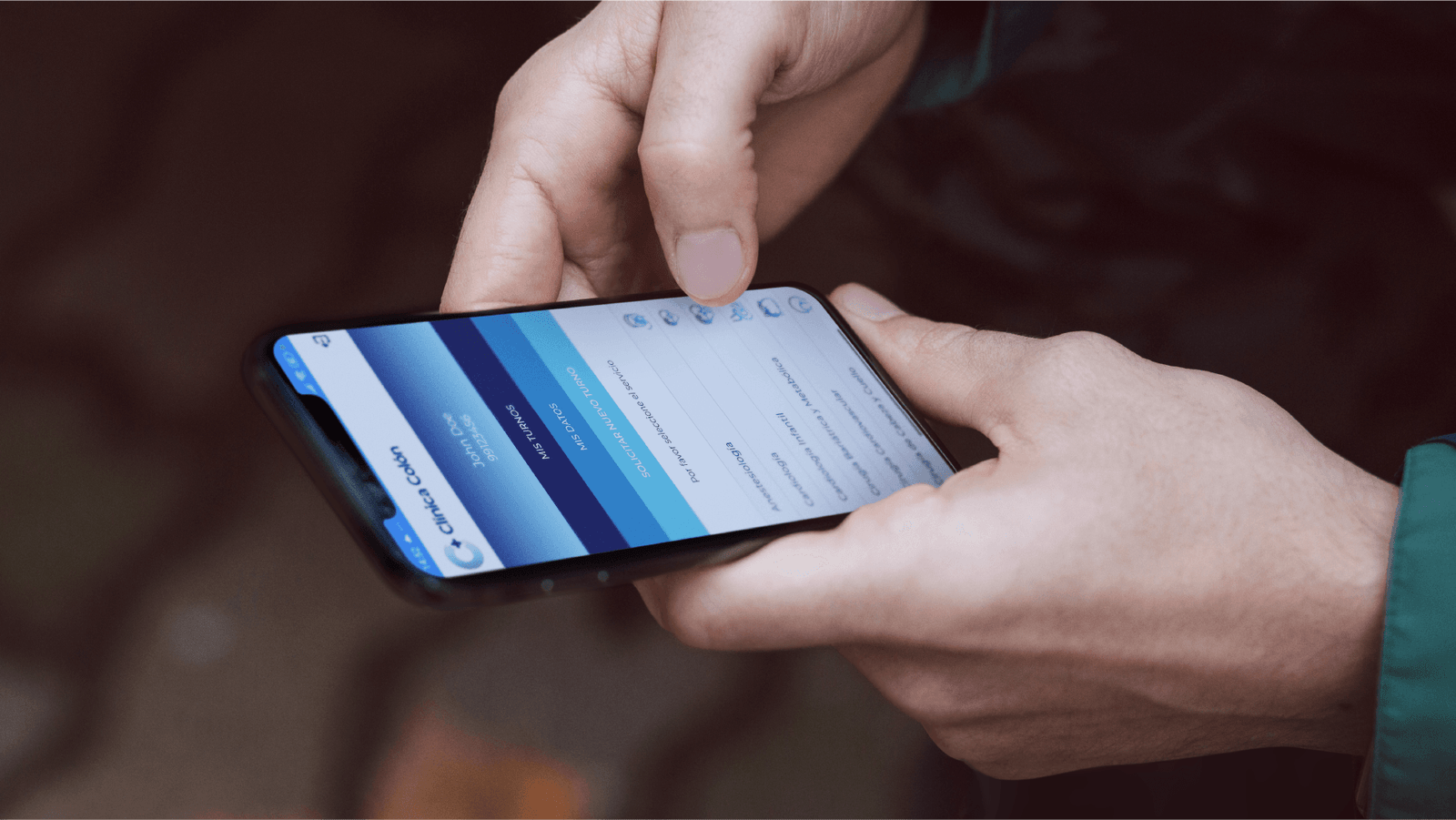 Desarrollo de App para turnos médicos Manos de hombre sosteniendo un smartphone en donde se ve la App de Clínica Colón Mar del Plata